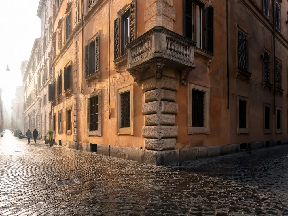 A Roman street corner where two ochre fronts angle away